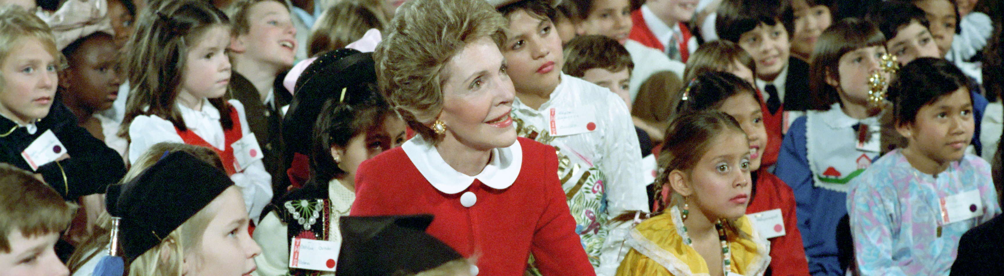 Nancy Reagan sitting with children on the floor.