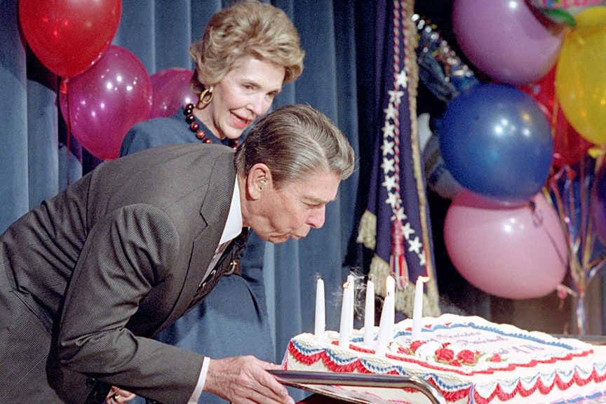 President Reagan blowing out candles on his birthday cake President Reagan blowing out candles on his birthday cake while Nancy Reagan looks on at a surprise 76th birthday party