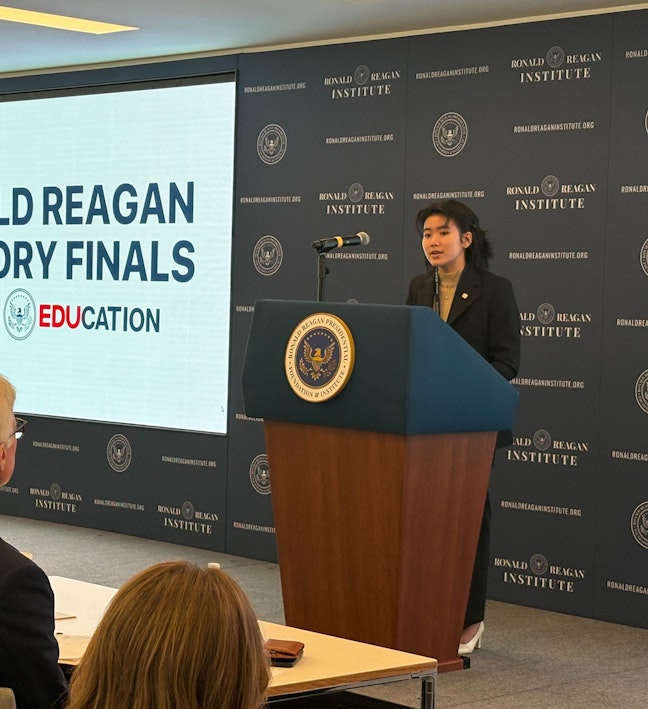 2024 Oratory Finalist Female Student at Presidential Podium with Judges