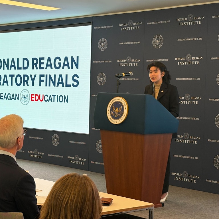 2024 Oratory Finalist Female Student at Presidential Podium with Judges