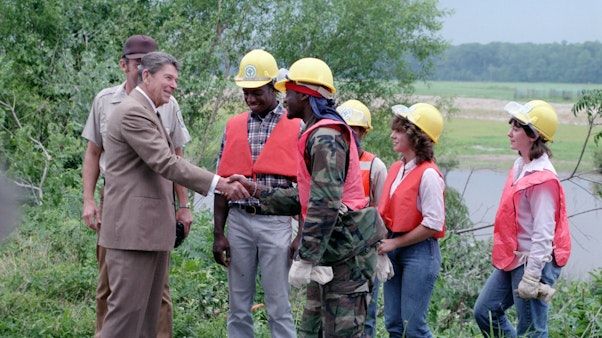 President Reagan handshake while visiting a youth conservation team President Reagan shakes hands with a group of men and women in hard hats and orange vests
