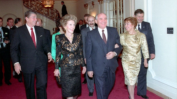 President Reagan and Nancy Reagan with Soviet General Secretary Gorbachev and Raisa Gorbachev attending a dinner at the Soviet Embassy in Washington, DC. 12/09/1987. Smiling couples walk down a hallway of red carpet