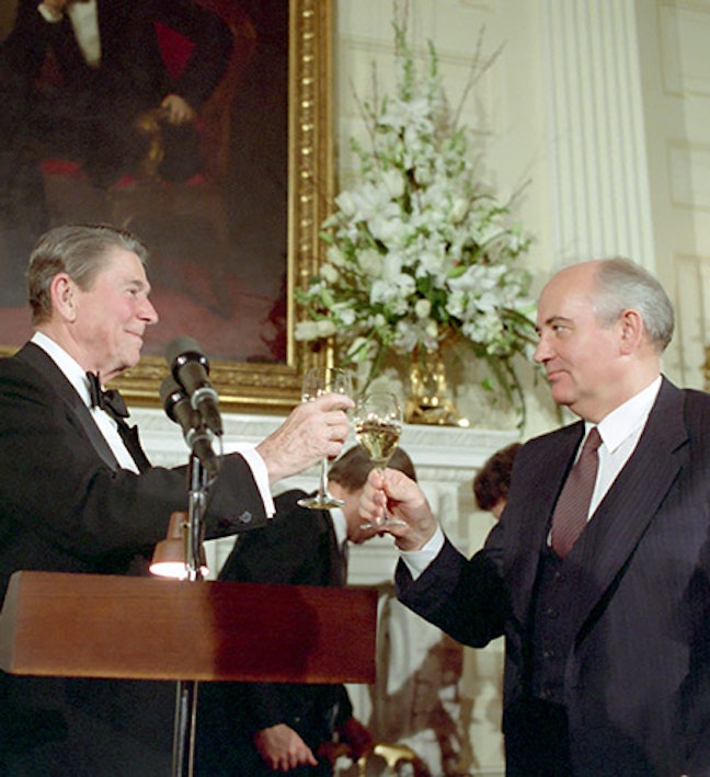 President Reagan and General Secretary Mikhail Gorbachev toast in the State Dining room during the Washington Summit. 12/08/1987. Two men toast champagne