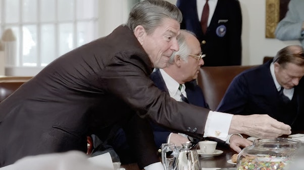 Reagan reaching for jelly beans Photo of Reagan reaching for a jar of jelly beans at a large brown table