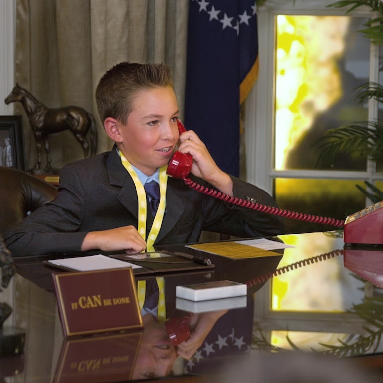 Kid taking phone call in oval office