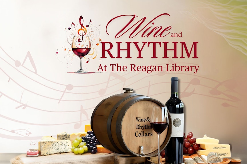 Photo of wine barrel with glss of wine, cheese, grapes.