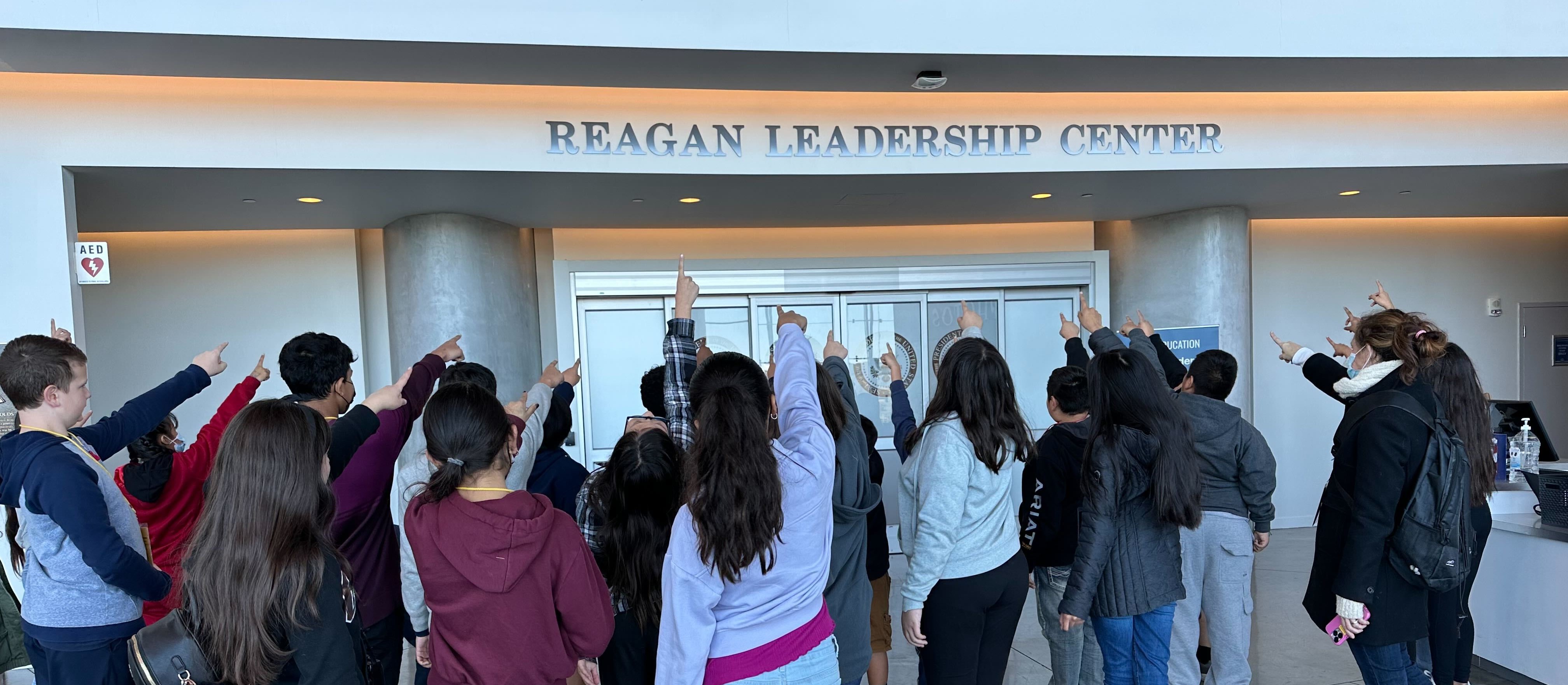 Students pointing at Reagan Leadership Center Simulation Entrance