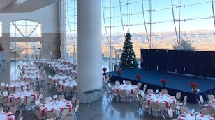 Tables set for a gathering, Christmas tree and stage.