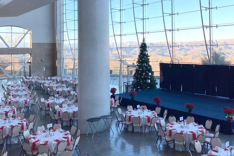 Tables set for a gathering, Christmas tree and stage.