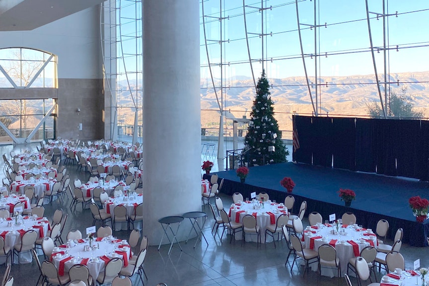 Tables set for a gathering, Christmas tree and stage.