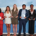 Students winning a scholarship holding a plaque.