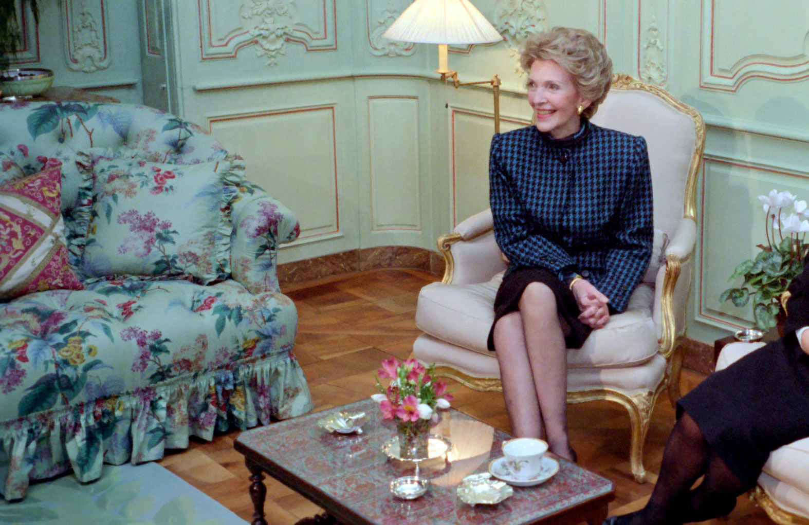Mrs Reagan smiling and sitting with tea on the coffee table