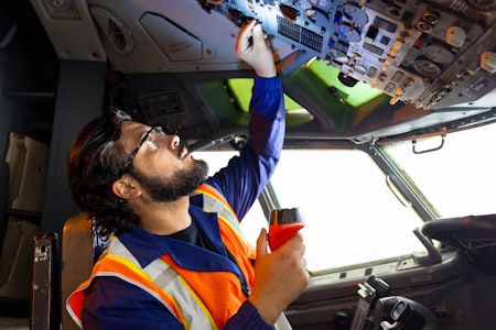 Man working on the electronics in a plane