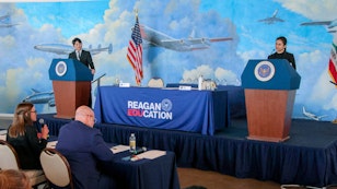 2 students, each on a podium for the debate