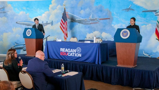 2 students, each on a podium for the debate
