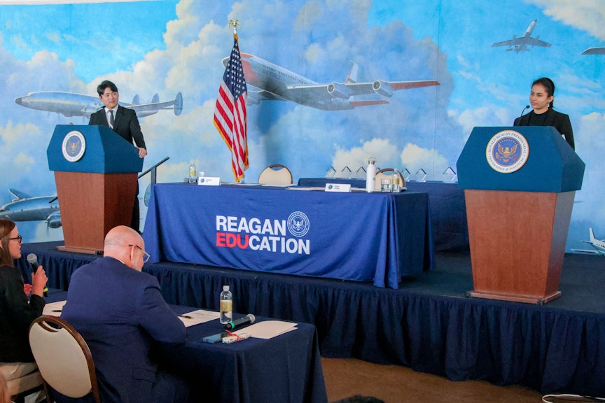 2 students, each on a podium for the debate