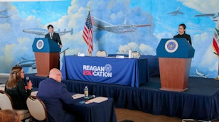 2 students, each on a podium for the debate