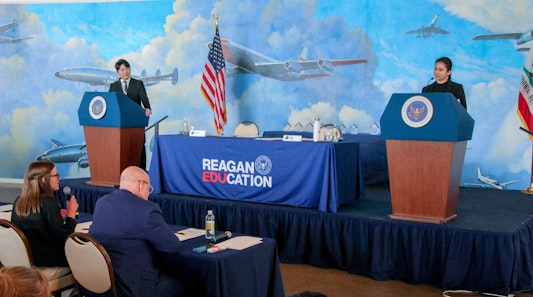 2 students, each on a podium for the debate