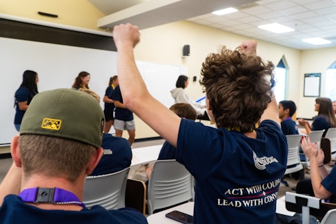 Student raising his hands in the air in triumph