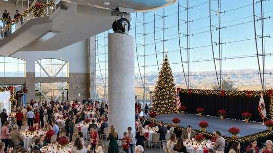 Guests enjoying a festive luncheon accompanied by live holiday music in a relaxed holiday setting