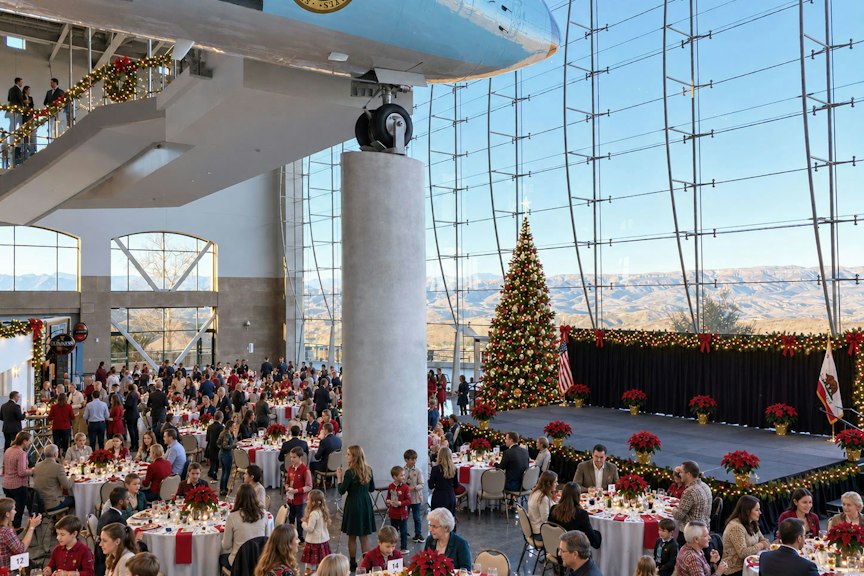 Guests enjoying a festive luncheon accompanied by live holiday music in a relaxed holiday setting